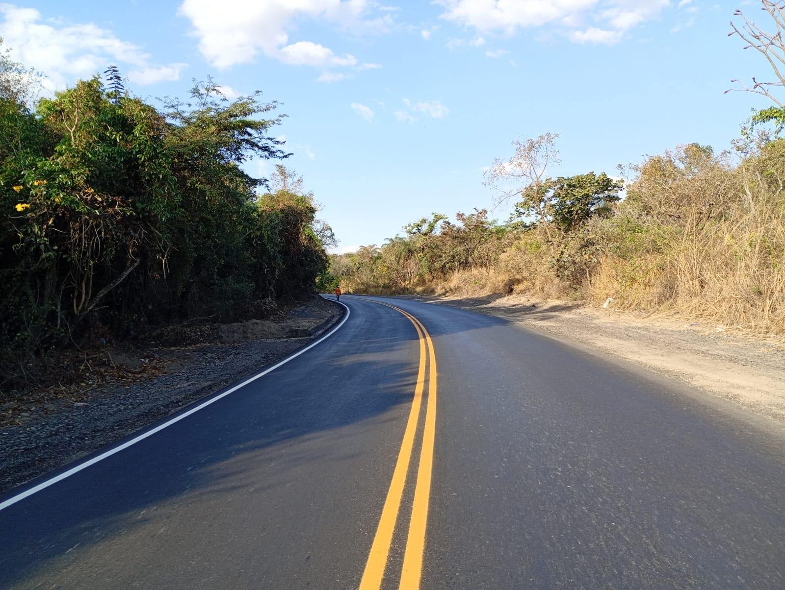 Rodovia recém-sinalizada, com faixa central dupla amarela e bordos brancos