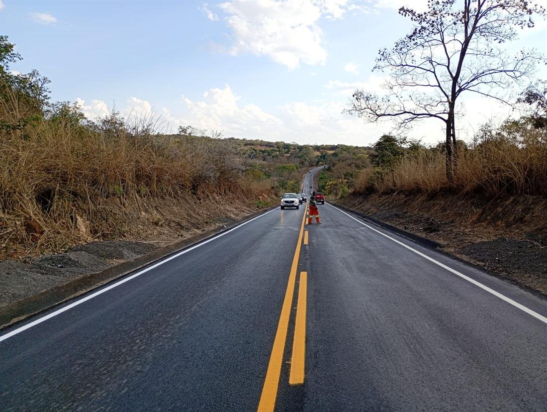 Trecho reto de rodovia com faixa dupla amarela e bordos brancos